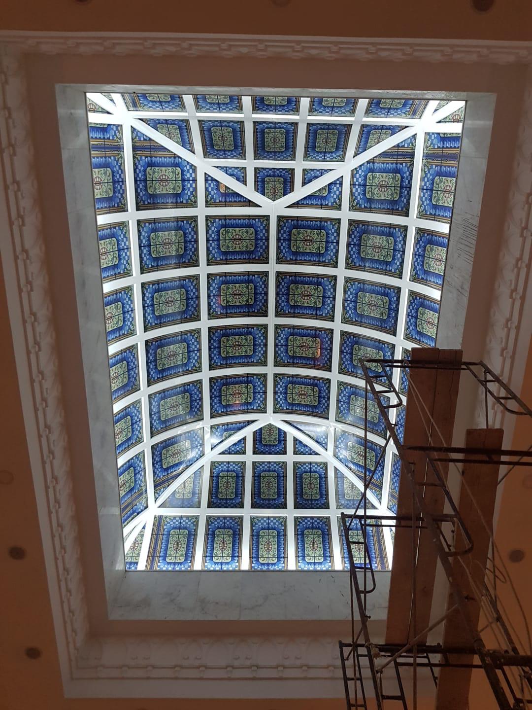 Decorative blue patterned glass ceiling with a white supporting frame
